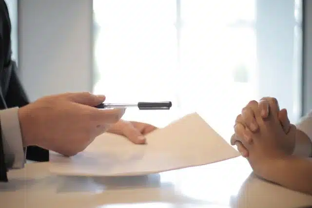 Close-up of a contract signing with hands over documents. Professional business interaction