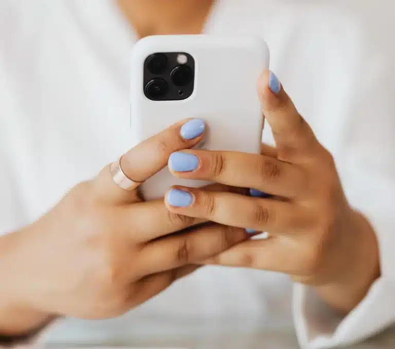 Close-up view of woman holding a smartphone indoors, showcasing modern technology
