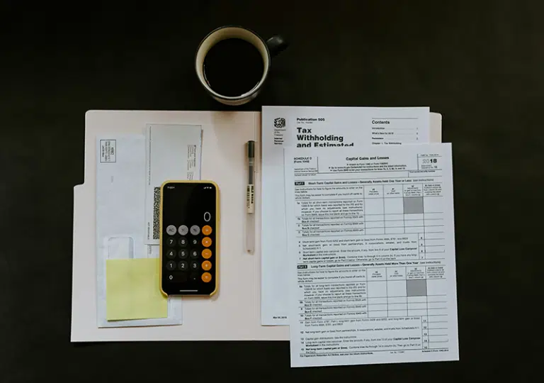 Overhead view of financial planning with debt and credit documents, calculator, and cash on blue background